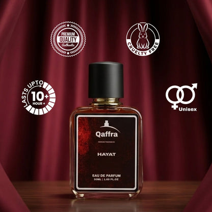 A bottle of Qaffra Hayat Eau de Parfum centered on a dark red draped backdrop, with promotional badges around it including 'Astra upto 10+ Hour', 'Quality Certified', 'Cruelty Free', and 'Unisex'.