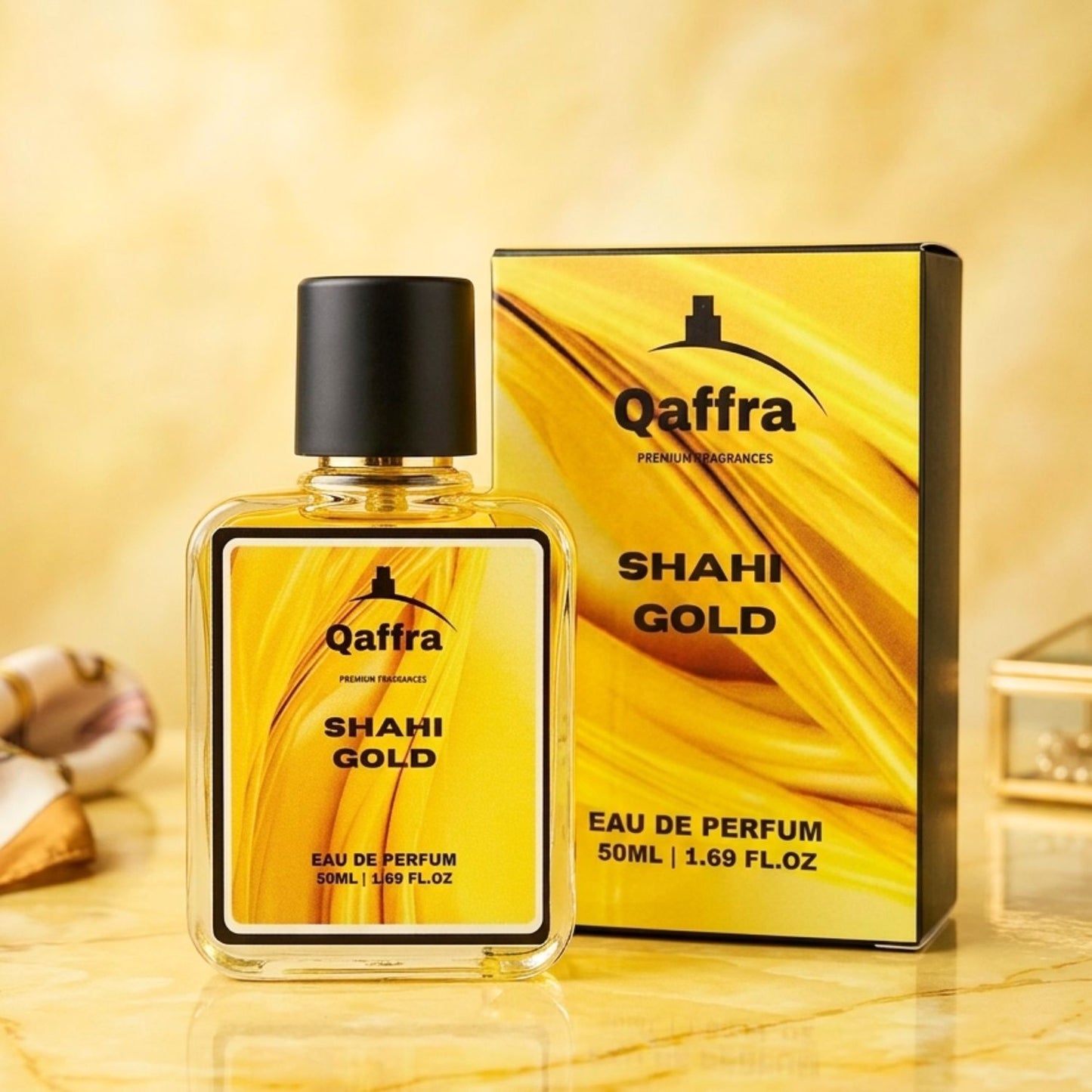 A Premium bottle and premium box of Qaffra Shahi Gold Eau de Parfum displayed on a warm beige marble surface with a matching blurred background